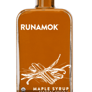 A bottle of maple syrup on top of a green background.