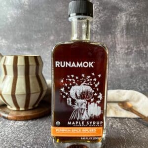 A bottle of maple syrup sitting on top of a table.