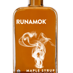 A bottle of maple syrup on a green background