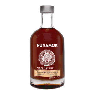 A bottle of maple syrup on a green background