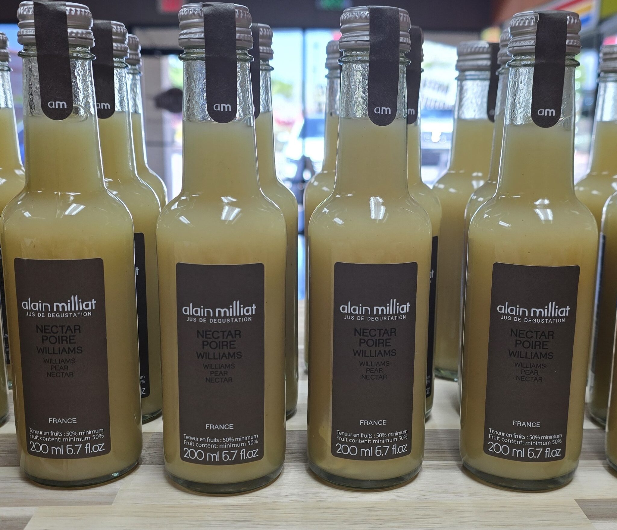 Bottles of pear nectar on display shelf.