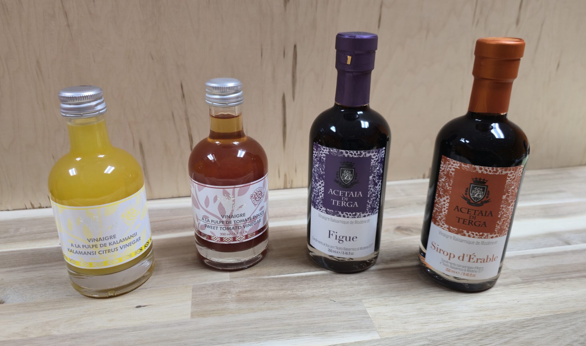 Four bottles of assorted syrups on table.